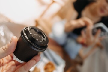 Presenting black cup of hot coffee in a cafe.