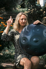 Naklejka premium a woman holds a handpan in her hands