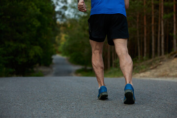 Closeup athletic strong legs of retired sportsman jogging