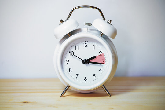 Vintage alarm clock showing change from daylight saving time and fall back to standard time, copy space