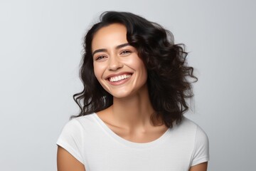 Closeup photo portrait of a beautiful young latin hispanic model woman smiling with clean teeth. Used for a dental ad. Isolated on light background.