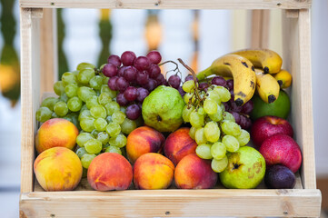 Fruits photography. A wood shelf full with bio fresh fruits like bananas, apples, grapes, nectarines, plums and pears.