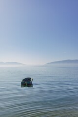 Small boat floating on the empty quiet sea.