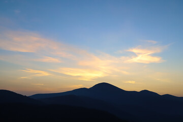 silhouette of Mount Petros and shining clouds in the sky before dawn