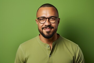 Portrait of a smiling african american man in glasses over green background