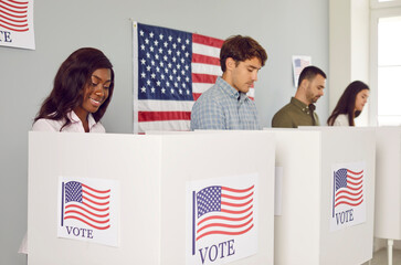 Group of happy diverse multiracial American citizens voting at polling station during democratic...