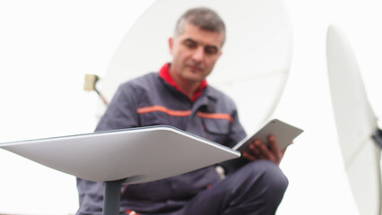 A man installs a satellite dish for fast Internet.