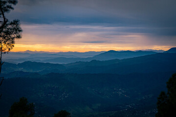 Beautiful landscape view of pine forest and sunset at himalayan range, Almora, Ranikhet, Uttarakhand, India with selective focus. Colourful sunset in Almora city, Kasardevi area.