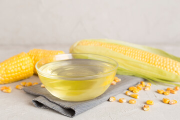 Corn oil with fresh cobs on wooden table