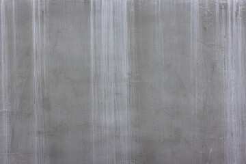 concrete outdoor wall with matte gray paint and white smudges - full-frame background and flat texture.