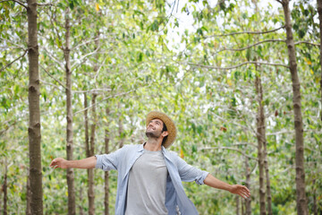 handsome man with beard in white shirt in a evergreen forest