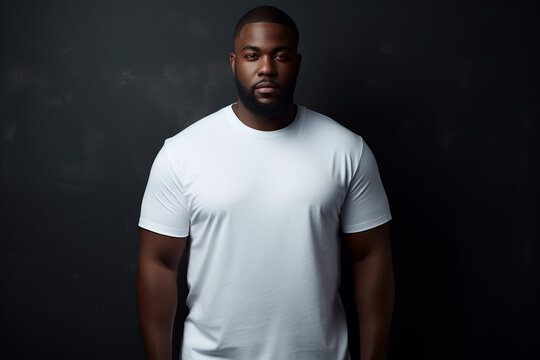 design mockup: black plus sized man wearing a blank white t-shirt, studio shot