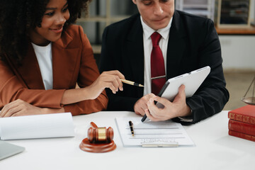 Business and lawyers discussing contract papers with brass scale on desk in office. Law, legal services, advice,  justice and law concept ..