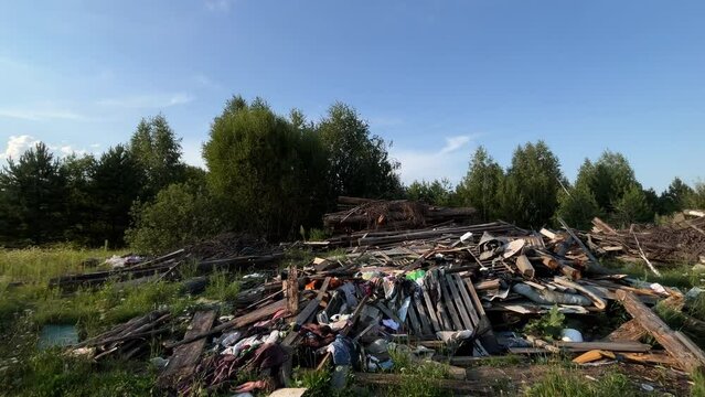 Remains of house Illegal dump near rural road forest village, environmental pollution concept. Rubbish garbage trash waste outdoors nature. Wooden boards logs grass contamination landscape countryside