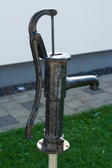 old water hand pump in retro design made of iron in the garden