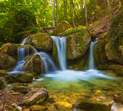 small beautiful waterfall on mountain river © Yuriy Kulik