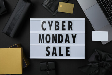 Cyber monday message on table with gifts and laptop.