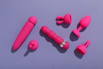 A collection of sex toys on a purple background.