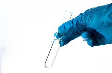 a test tube with liquid in the hand in a blue glove