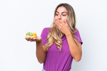 Young pretty Uruguayan woman holding a tartlet isolated on white background with surprise and shocked facial expression