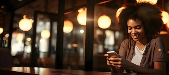 Beautiful black woman using her phone in coffee shop. Businesswoman