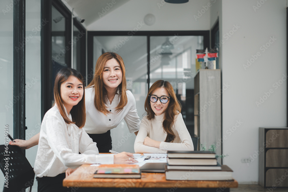 Poster portrait of a smiling group of diverse corporate colleagues analyzing documents while sitting on a t