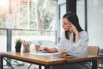 Overworked businesswoman suffering from headache and thinking how to end work.