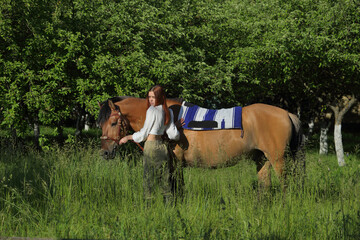 Young groom cowgirl with horse outdoor