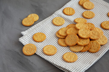 Round Crispy Crackers with Sea Salt on a gray background, side view.