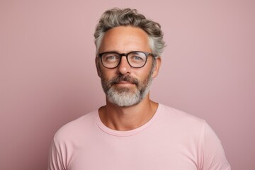 Portrait of handsome middle-aged man with gray beard and mustache in pink t-shirt and eyeglasses. - obrazy, fototapety, plakaty