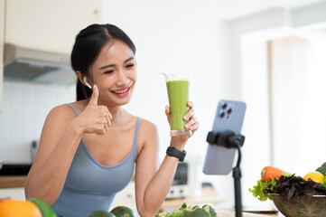 An attractive Asian female online nutrition coach is sharing her healthy green smoothie recipe.