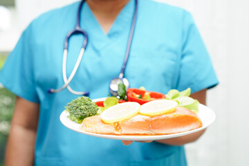 Asian Nutritionist holding healthy food for patient in hospital, nutrition and vitamin.