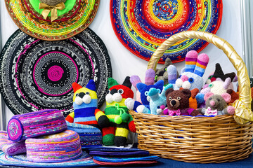 Multicolored knitted handmade children toys in basket. Homemade needlework and embroidery.