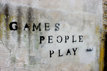 Sign on a wall Games people play. Vandalism, graffiti