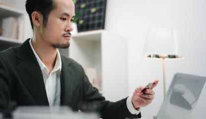 Asian businessman smiling and happy doing online shopping outside office building, man using mobile...