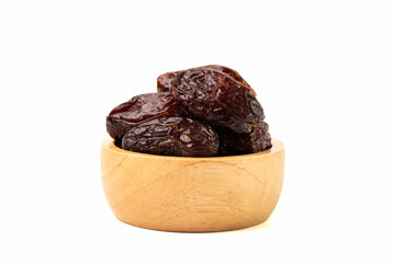 Heap of dried dates in wooden bowl isolated on white background.