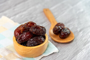 Dried dates fruit in wooden bowl.