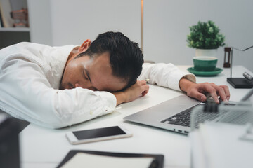 Obraz premium Asian businessman sleeping tired lying on the table, man at work 
