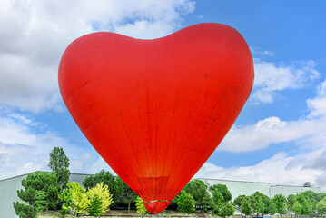 Colorful hot air balloon flying over blue sky with white clouds	