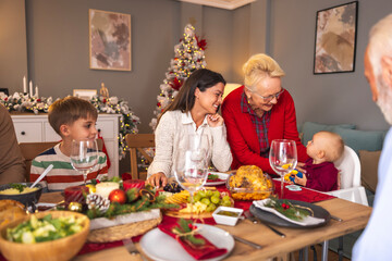 Happy multi-generation family gathered at home for Christmas dinner