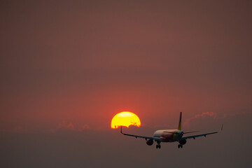 Fototapeta na wymiar Plane landing at sunset