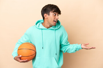 Handsome young basketball player man isolated on ocher background with surprise expression while...