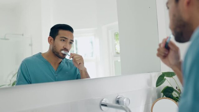 Dental, bathroom mirror and man brushing teeth with toothbrush, toothpaste and home morning treatment. Reflection, enamel care routine and person cleaning mouth for oral shine, hygiene or wellness