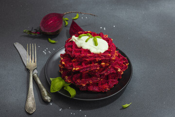 Homemade beetroot Belgian waffles with sauce. Gluten free vegan food with vegetables