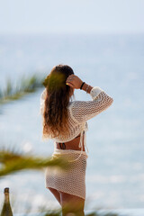 Woman seen from behind on the beach on a summer day.