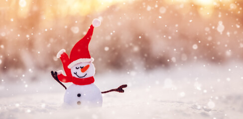 Little handmade snowman on the white snow on blue background.
