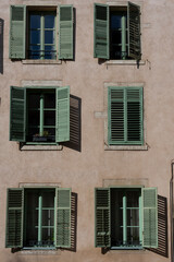 Obraz premium Nancy, France - 09 02 2023: View of a typical facade of a house, with green shutters and pink wall in the city center.