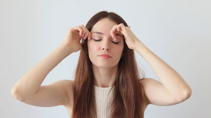 Fototapeta premium A beautiful woman gives a facial massage with her hands