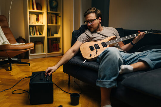 Man connecting electric guitar to an amplifier.