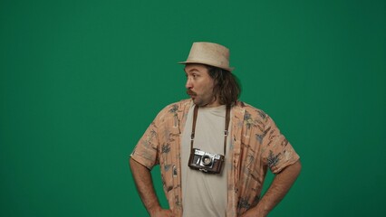 Man traveller in casual clothing and straw hat with old film camera looking at the side, surprised...